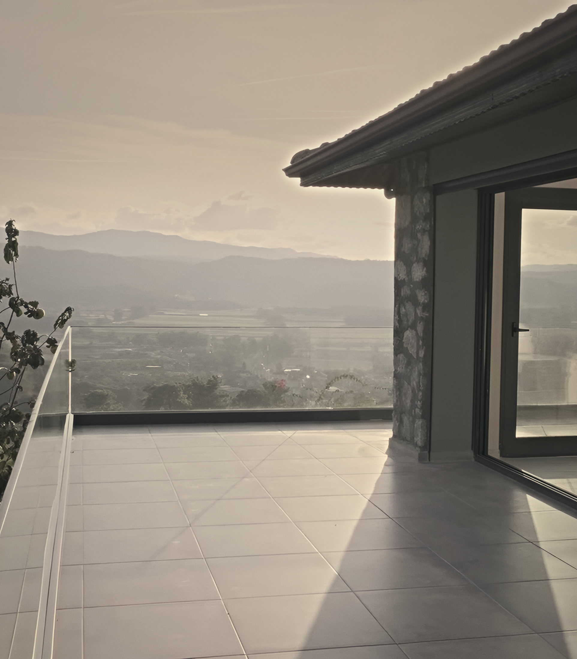 The upper terrace with its glass balustrade, looking over the valley in soft evening light